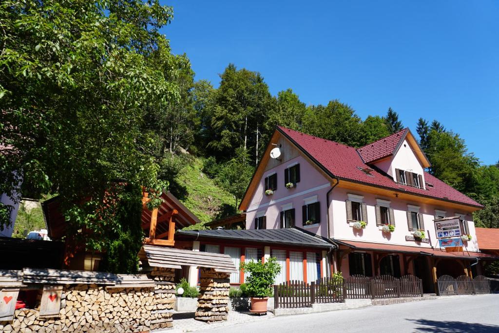 ein großes weißes Haus mit rotem Dach in der Unterkunft Guest House Gostišče Gačnk V Logu in Cerkno