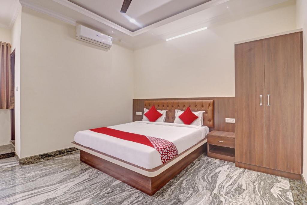 a bedroom with a large bed with red pillows at Super Collection O Ashraya Paradise in Bengaluru