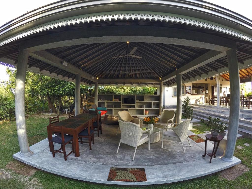 a gazebo with a table and chairs under it at The Horizon Hill Top Villa in Unawatuna