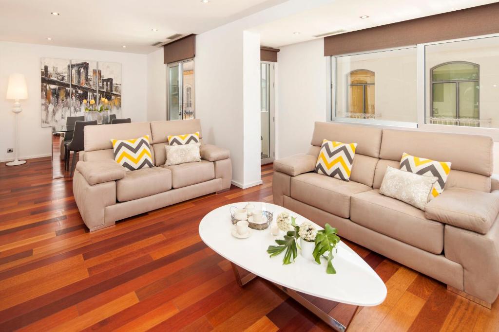 a living room with two couches and a coffee table at INMálaga Granada 2 in Málaga