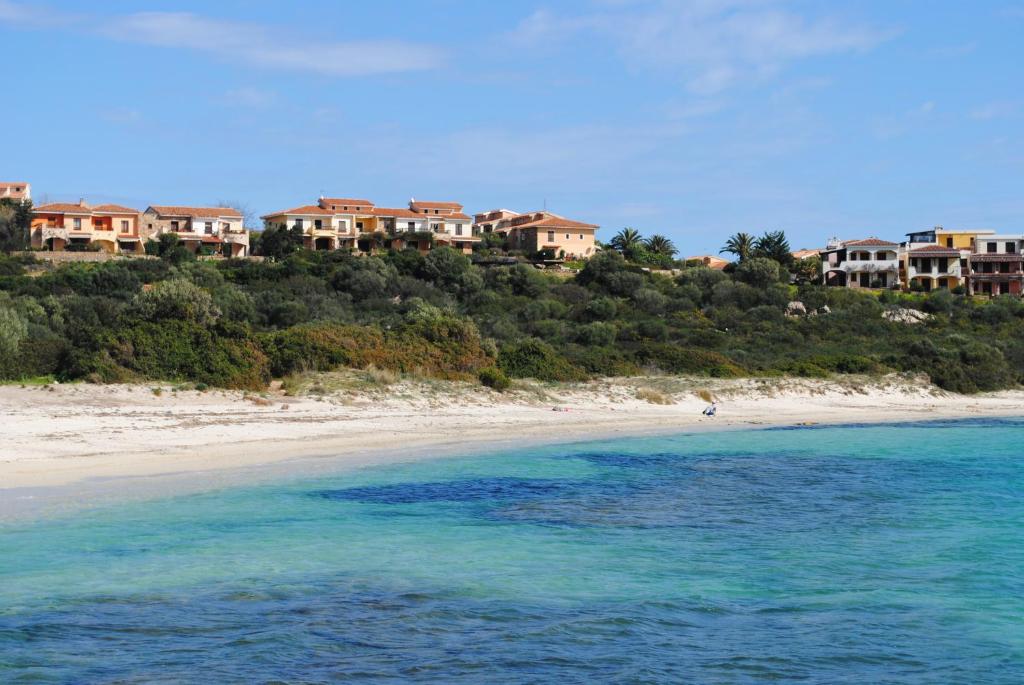 a view of a beach with houses on a hill at Appartamenti Spiaggia Bianca in Golfo Aranci
