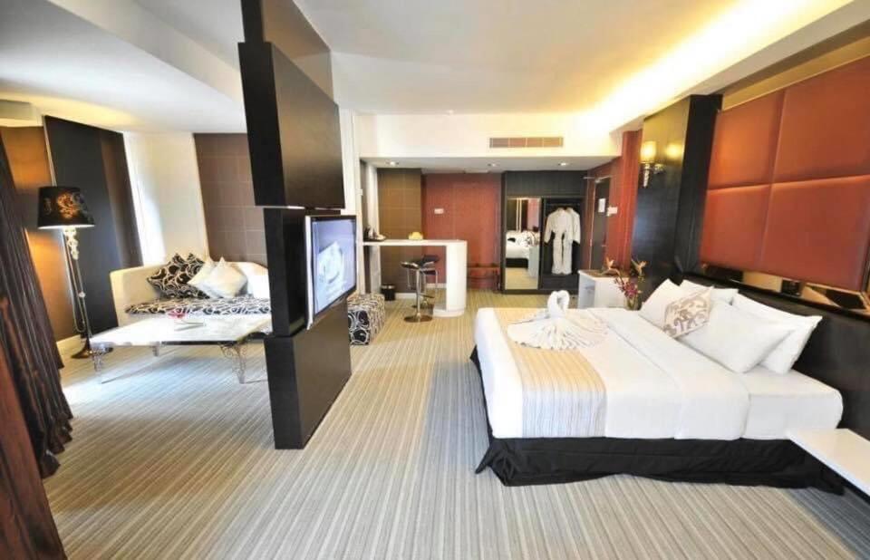 a hotel room with a large bed and a television at Capitol Park By Sahara Hotel in Jakarta
