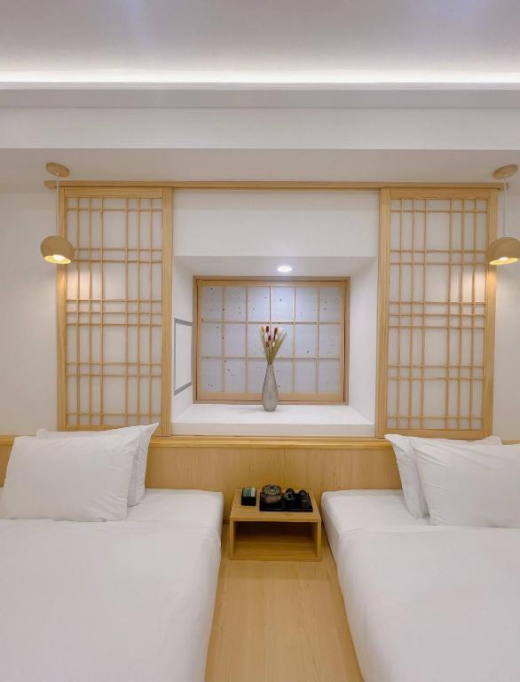 two beds in a room with a window at star house akihabara ueno tokyo in Tokyo