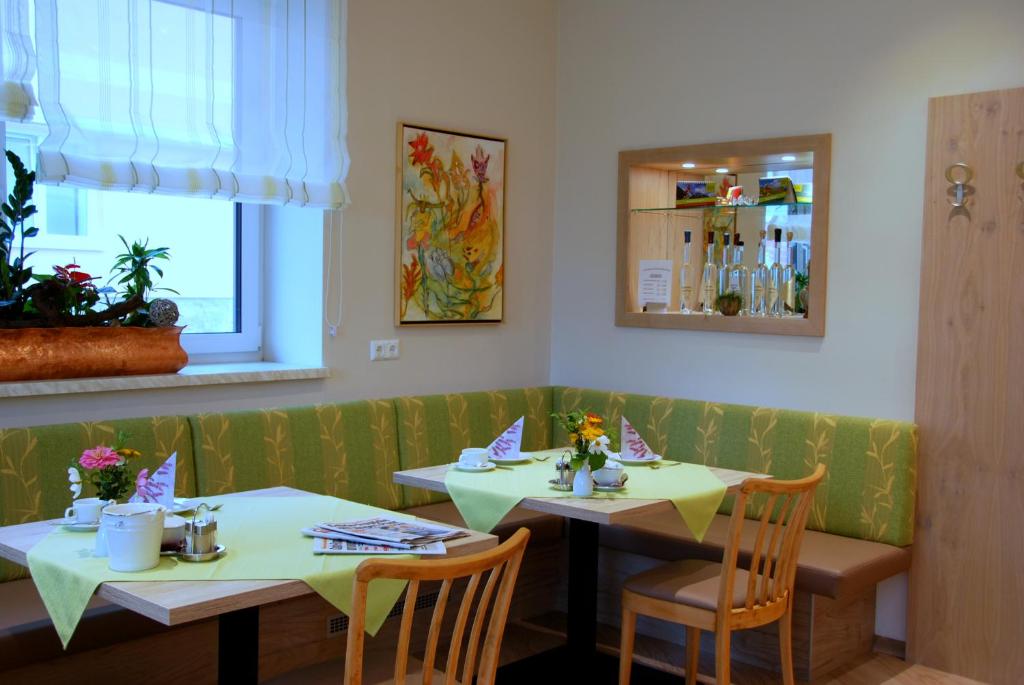 two tables in a restaurant with yellow tables and chairs at Pension Ehrenfried - Hotel garni in Kindberg