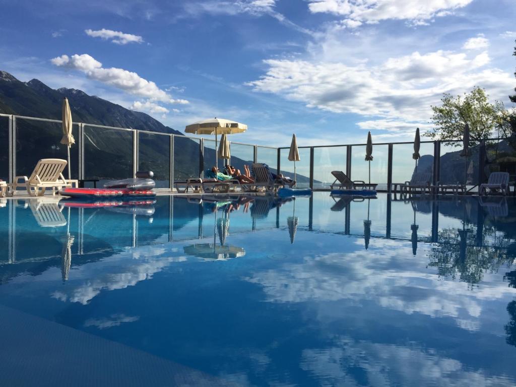 リモーネ・スル・ガルダにあるホテル カポ レモールの水辺の景色を望むスイミングプール