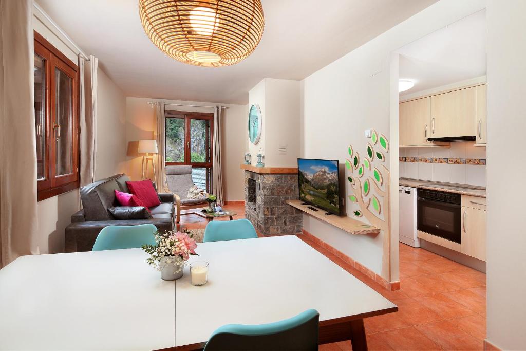 a kitchen and living room with a table and chairs at PirineosNature Apartments in Plan