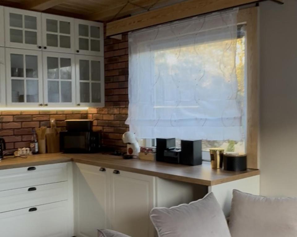 een keuken met witte kasten en een raam bij Domek na Kaszubach u Doroty 