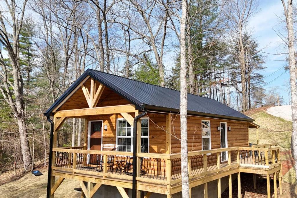 a cabin in the woods with a black roof at Alone At Last - New LUX - WiFi - Hot Tub in High Falls