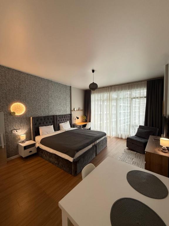 a large bedroom with a bed and a couch at Вид на закат, море и бассейн in Batumi