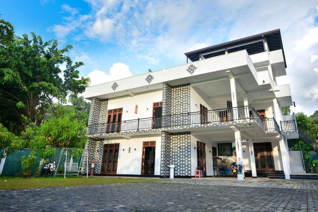a white building with a balcony on the side at Sun Side Villa in Ginimellagaha West