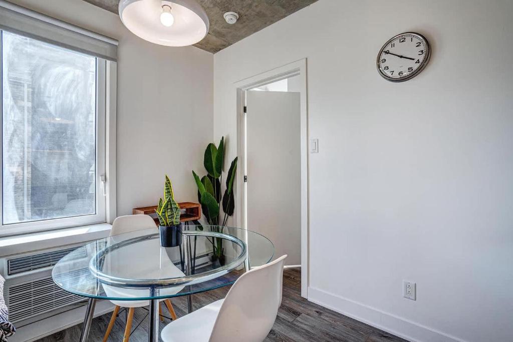 ein Esszimmer mit Glastisch und Stühlen in der Unterkunft Corporate Stays Le Shaughn 1 BR - Double Bed in Montreal