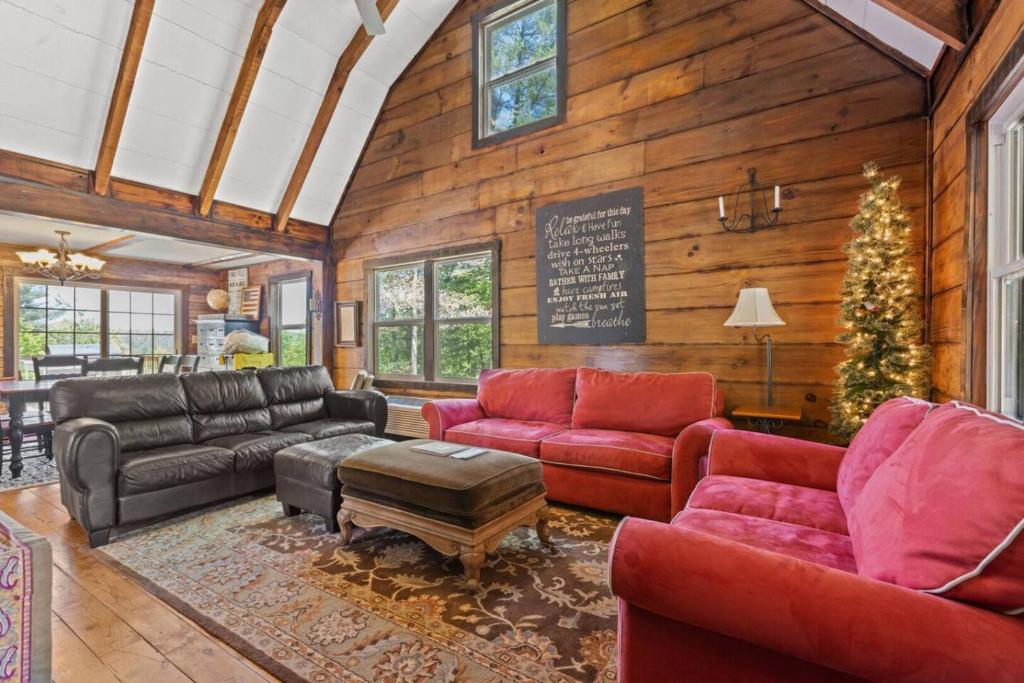 a living room with red furniture and a christmas tree at WiFi Pet Friendly Secluded Knotty By Nature in High Falls