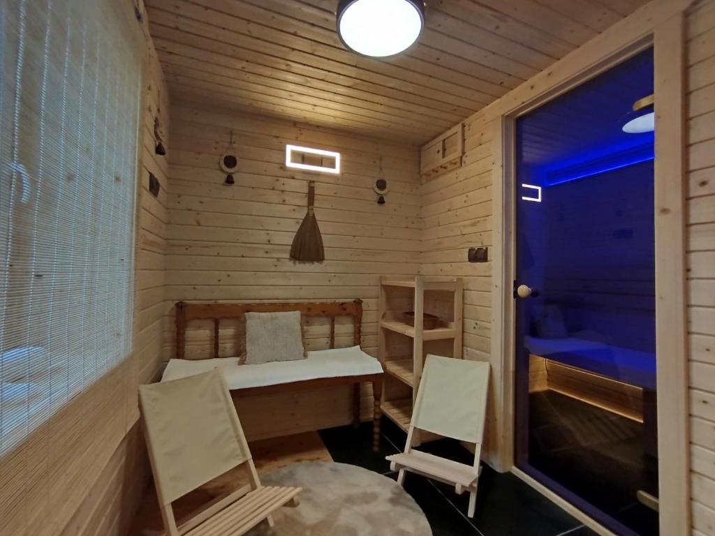 a small room with two chairs and a bed and a window at Ubytovanie na Trojke in Liptovský Ondrej