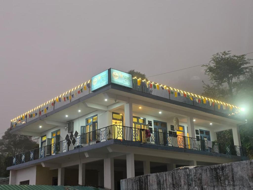 a building with a balcony with lights on it at Aangan Royal Stay in Dharmsala
