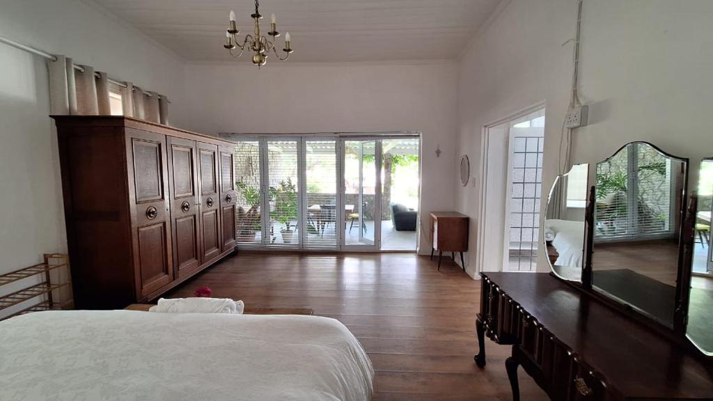 a bedroom with a bed and a dresser and a mirror at Karoo Sunset Villa in Richmond