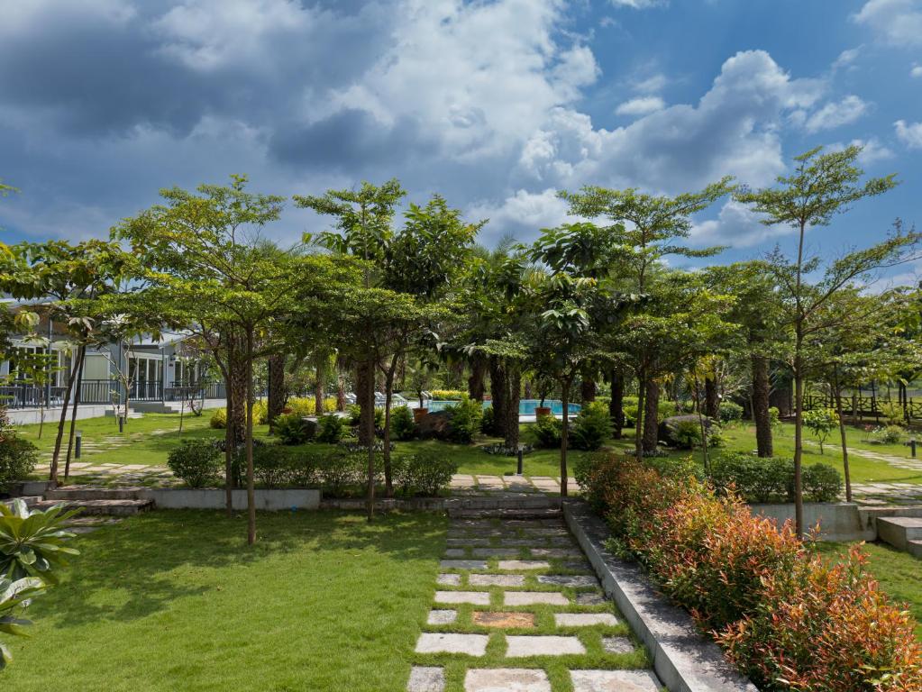 The Nest, Karjat في كارجات: حديقة بها أشجار ومسار حجري