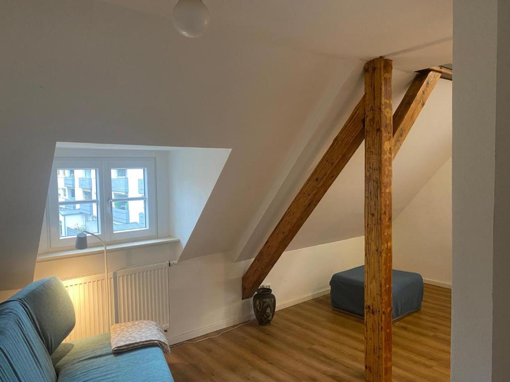 a living room with a blue couch and a window at Gästewohnung Augsburg - Spickel in Augsburg