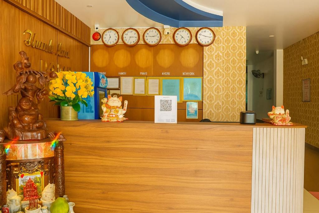 un hall doté d'un comptoir avec des horloges murales dans l'établissement Hong Phuc Hotel 2 Da Nang, à Đà Nẵng