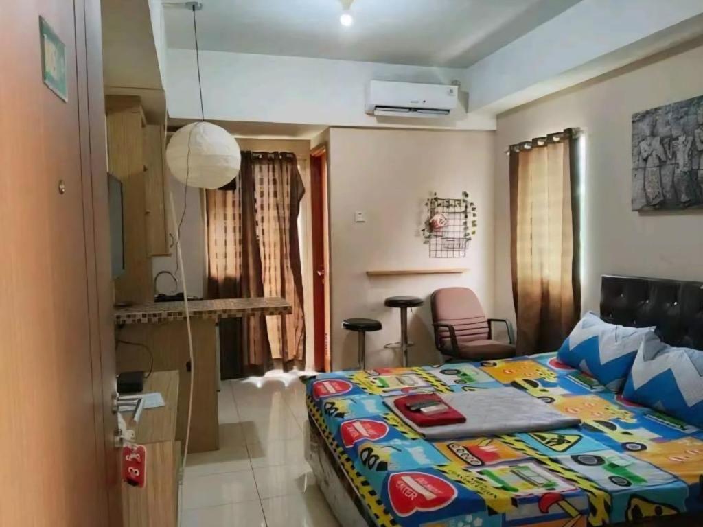 a bedroom with a bed with a colorful comforter at Bram Rooms Green Lake View Ciputat in Pondokcabe Hilir