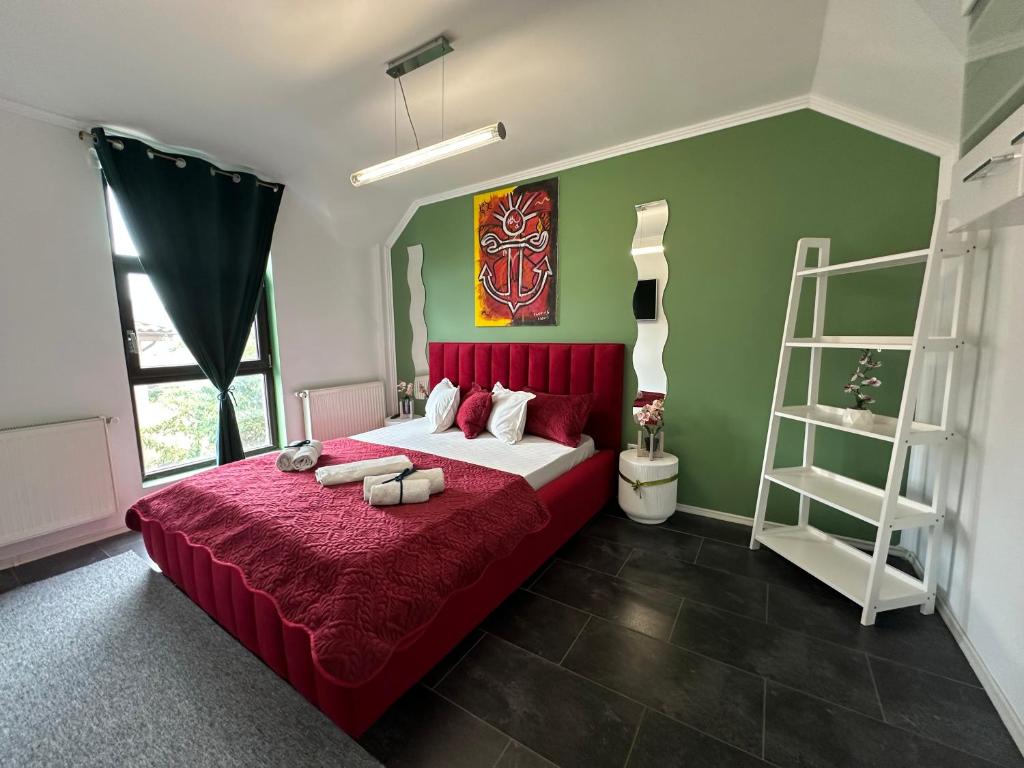 a bedroom with a large bed with a red blanket at Vitamine Central Apartment in Craiova