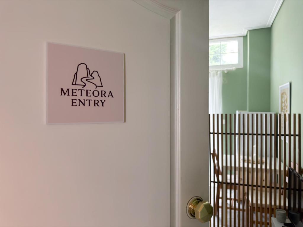 a white door with a sign on it next to a crib at Meteora Entry in Kalabaka
