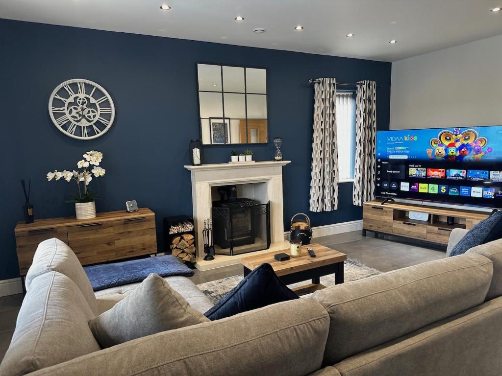 a living room with a couch and a fireplace at Modern Retreat with Hot Tub and Cinema in Cuckney