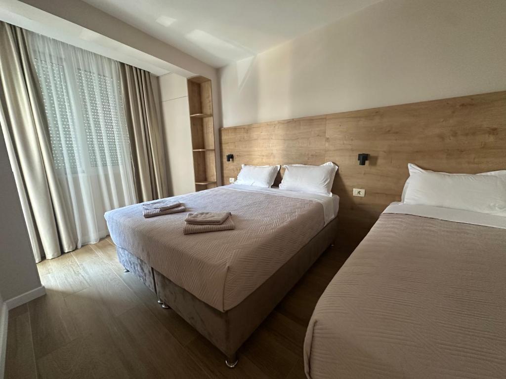 a hotel room with two beds and a window at Apartmani Jedro in Rafailovici