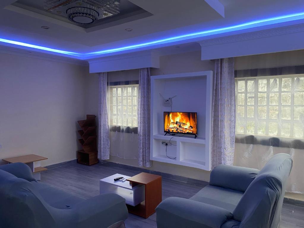 a living room with a couch and a fireplace at Brixton BnB in Naivasha