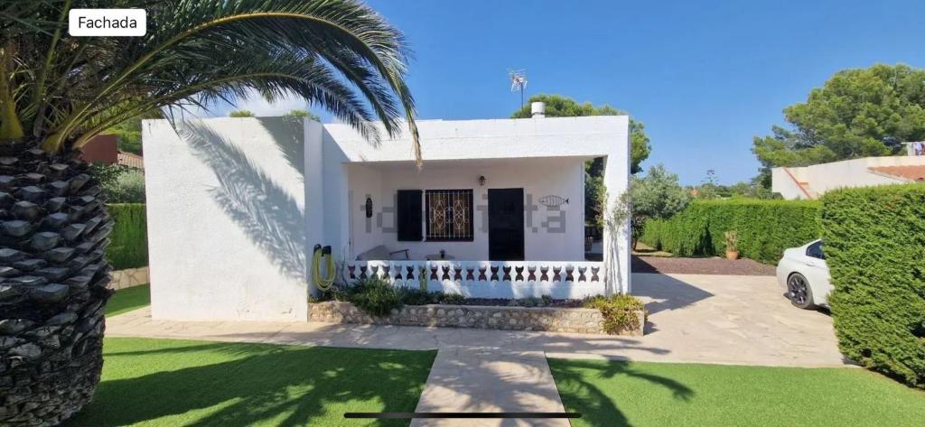 a white house with a palm tree and a driveway at Mar i Cel 54 in Calafat