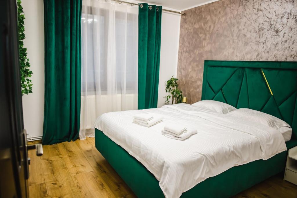 1 dormitorio con 1 cama verde con sábanas blancas en Melissa Home, en Bucarest