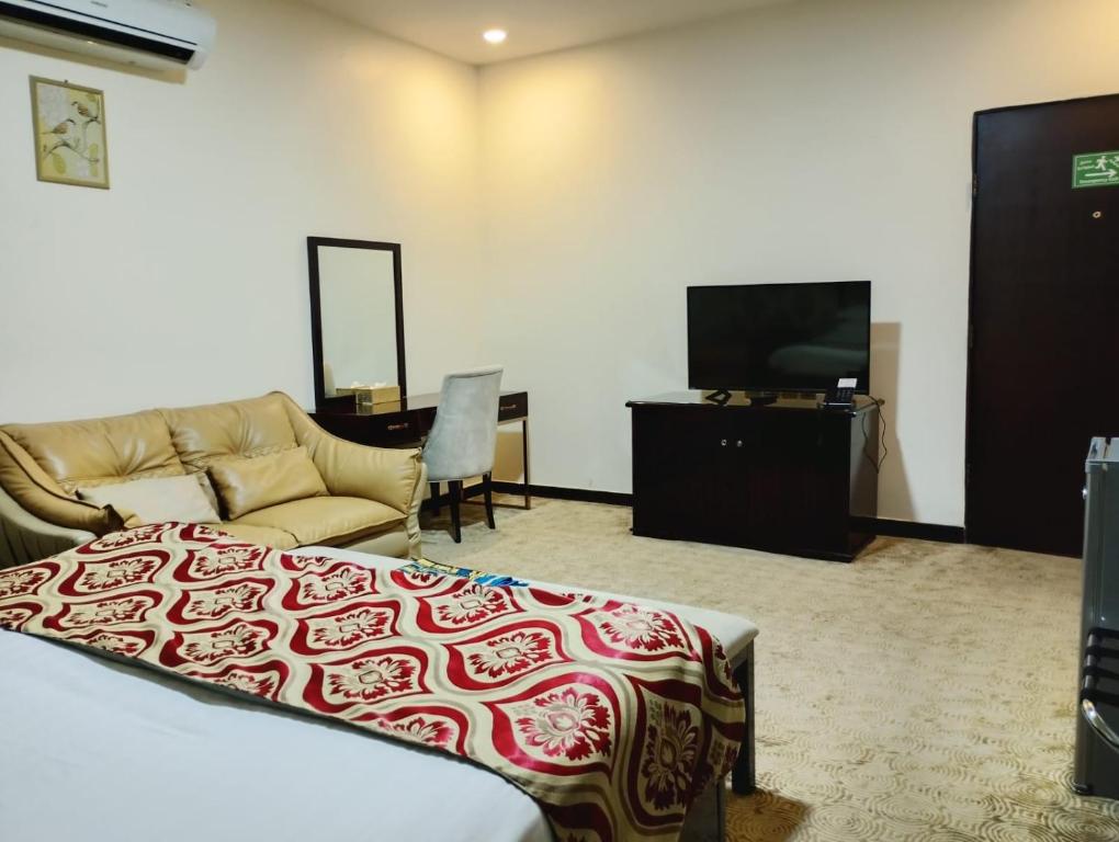 a living room with a couch and a tv at فندق مرايا بارك in Najran