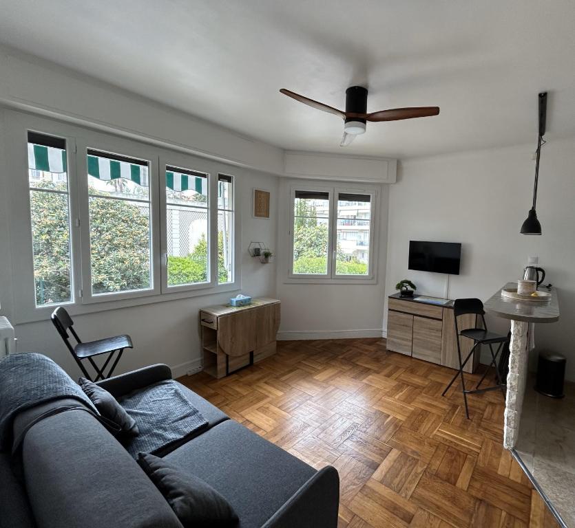 Una sala de estar con un sofá y un ventilador de techo. en Le 29 Promenade des Anglais - Golden Square, en Niza