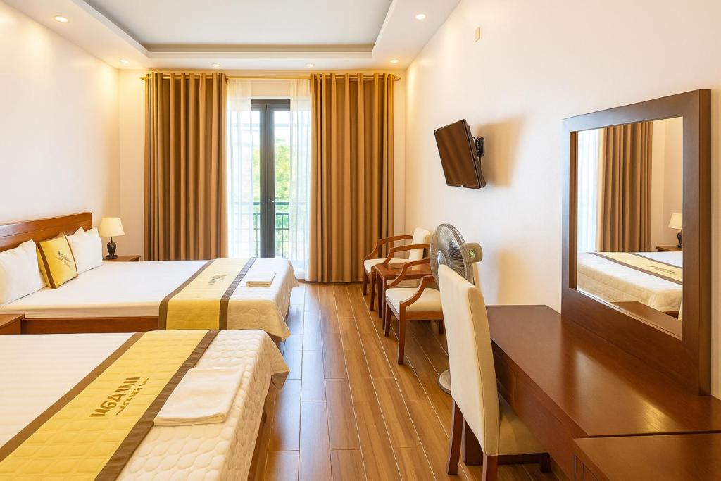 a hotel room with two beds and a table at Hotel Ngoc Anh - Van Don in Quang Ninh