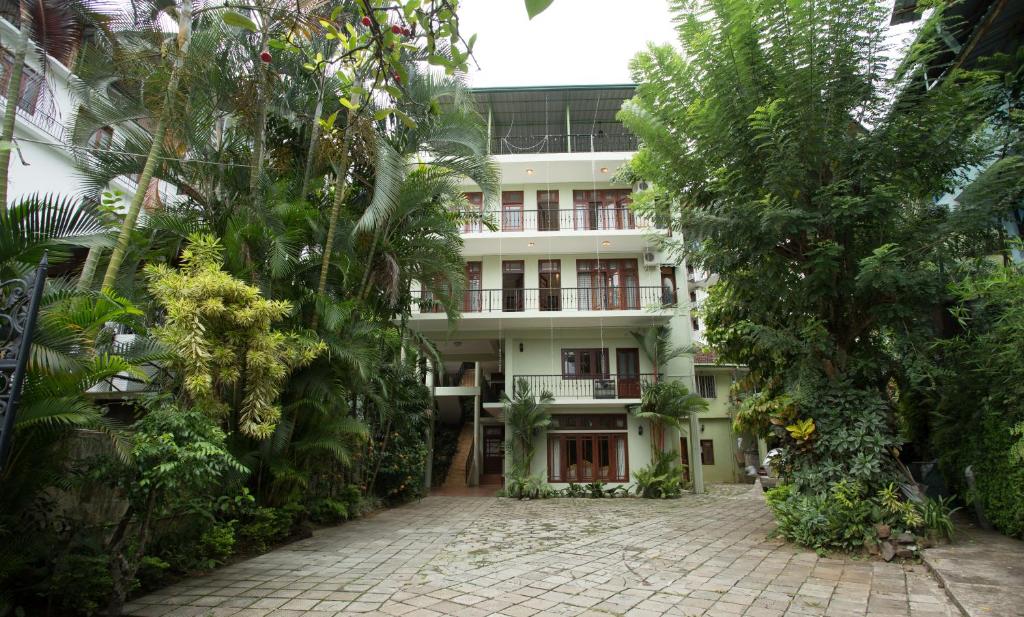 a white building with trees in front of it at Amanda Hills in Kandy