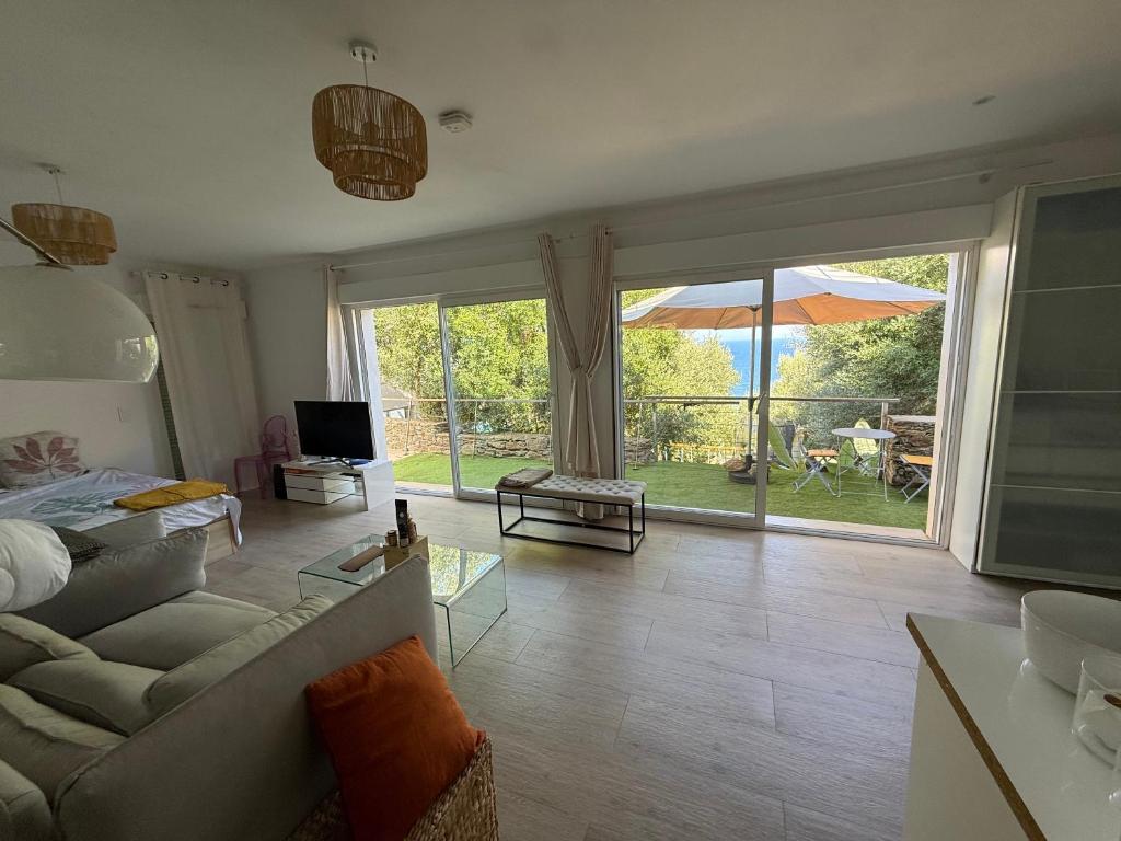 a living room with a couch and a large sliding glass door at Villa Pietranera in San-Martino-di-Lota