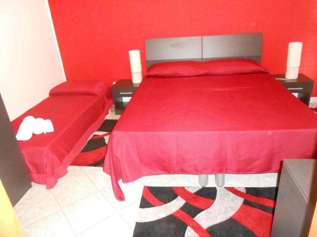 een slaapkamer met een rood bed met een rode sprei bij B&B Paradiso in Falerna