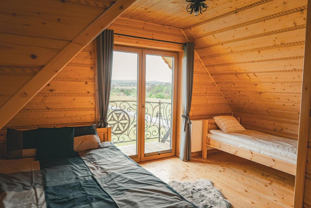 a bedroom with a bed and a large window at Dziki Raj - domki z widokiem na Tatry oraz Babią Górę in Jabłonka