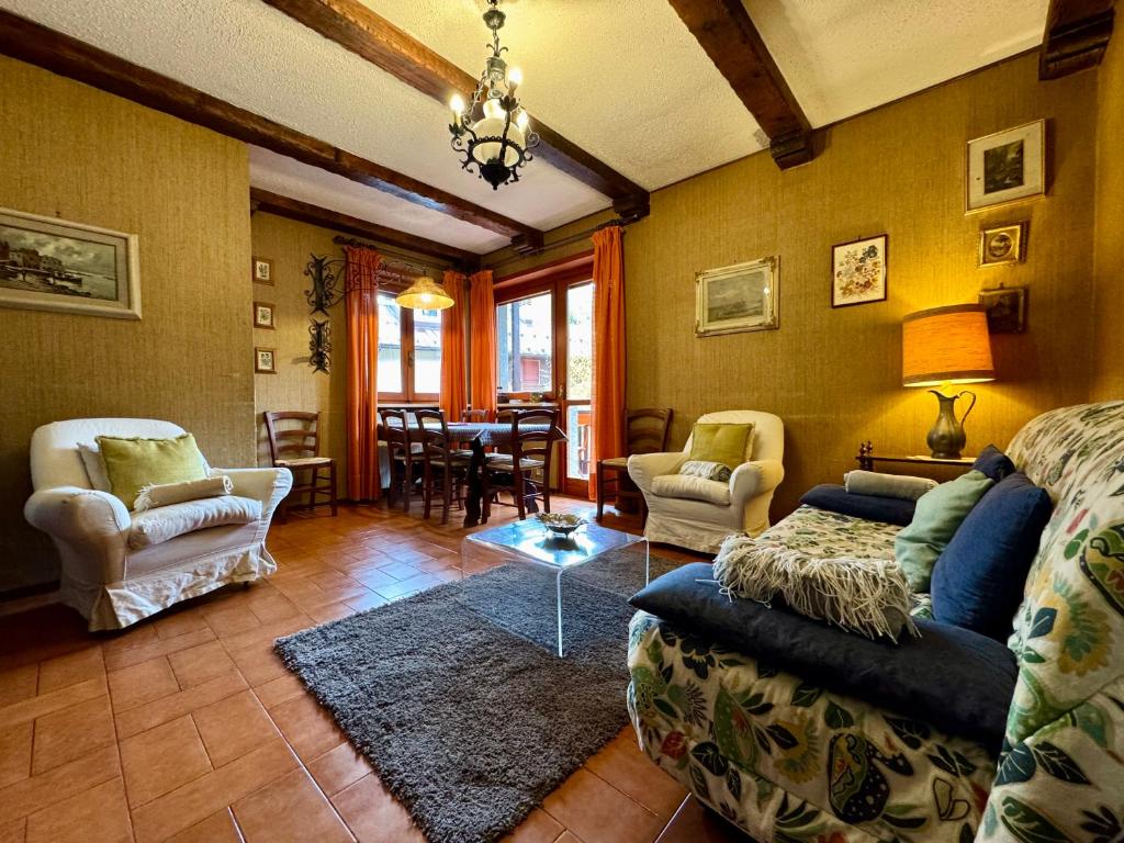 a living room with a couch and chairs and a table at Ampio appartamento per 8 a due passi dal centro in Bardonecchia