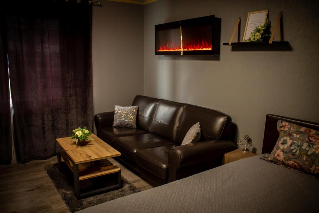 a living room with a leather couch and a coffee table at Pasaku apartaments in Cēsis