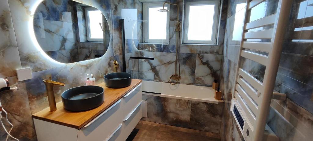 een badkamer met twee wastafels en een spiegel bij Maison moderne et chaleureuse à Colmar in Colmar