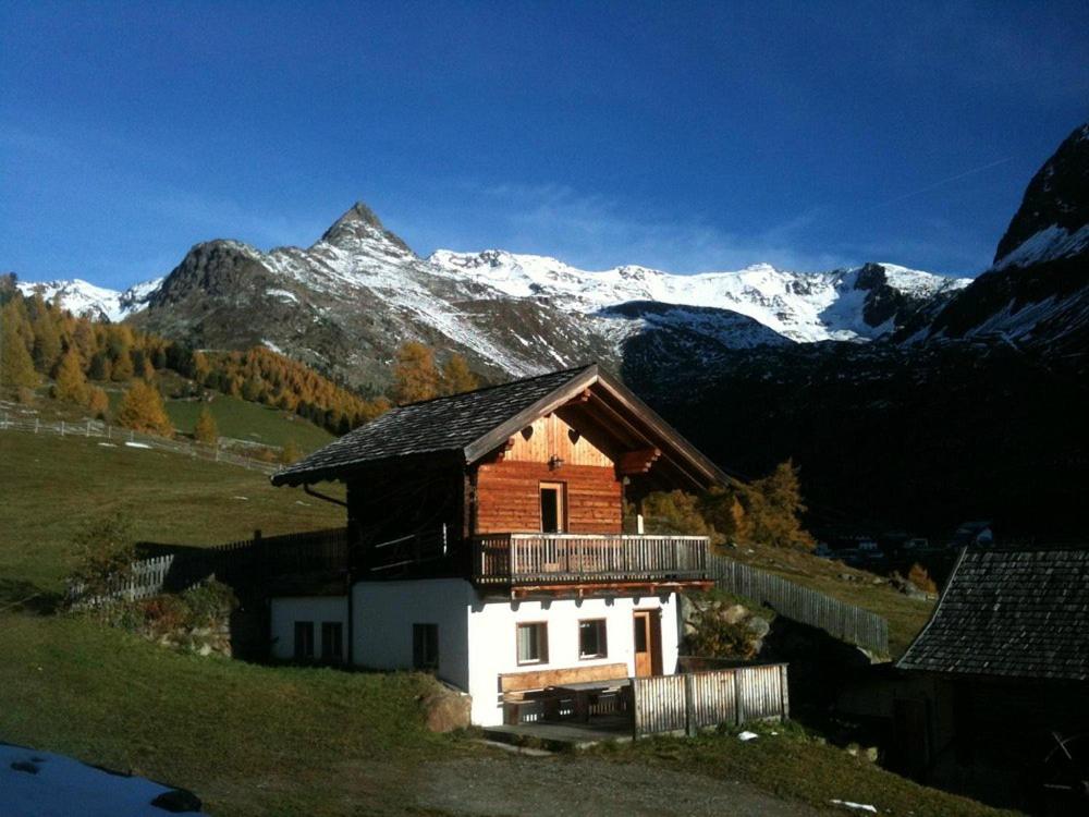 a house in a field with mountains in the background at Wieshof Schnals Bauernhofurlaub in Maso Corto