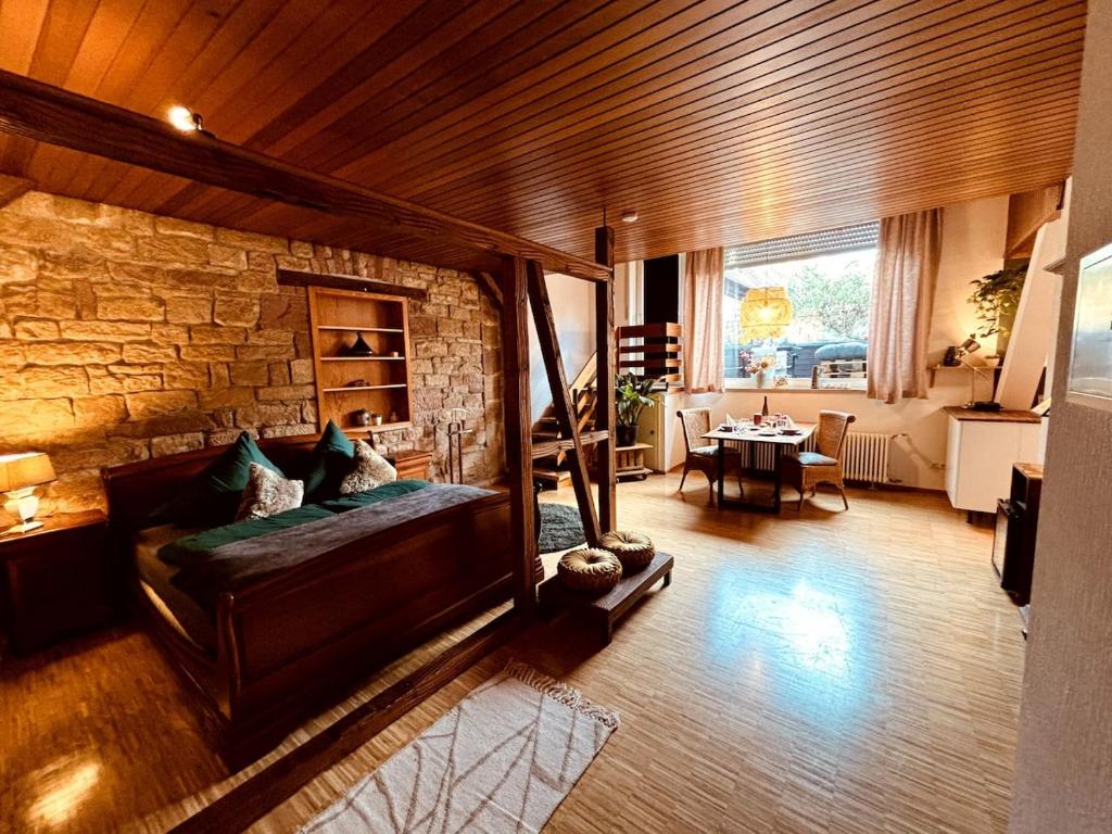 Una sala de estar con un sofá y una pared de piedra. en Ferienwohnung zum Woibauer, en Deidesheim