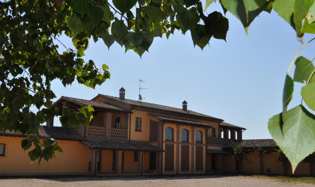 an exterior view of a house with a tree at Il Casale Giallo in Montefalco