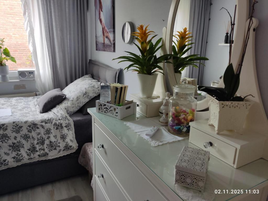 a bedroom with a bed and a dresser with plants at Deluxe Einzelzimmer nur für max 1 Nacht buchbar abends rein morgens raus in Bielefeld