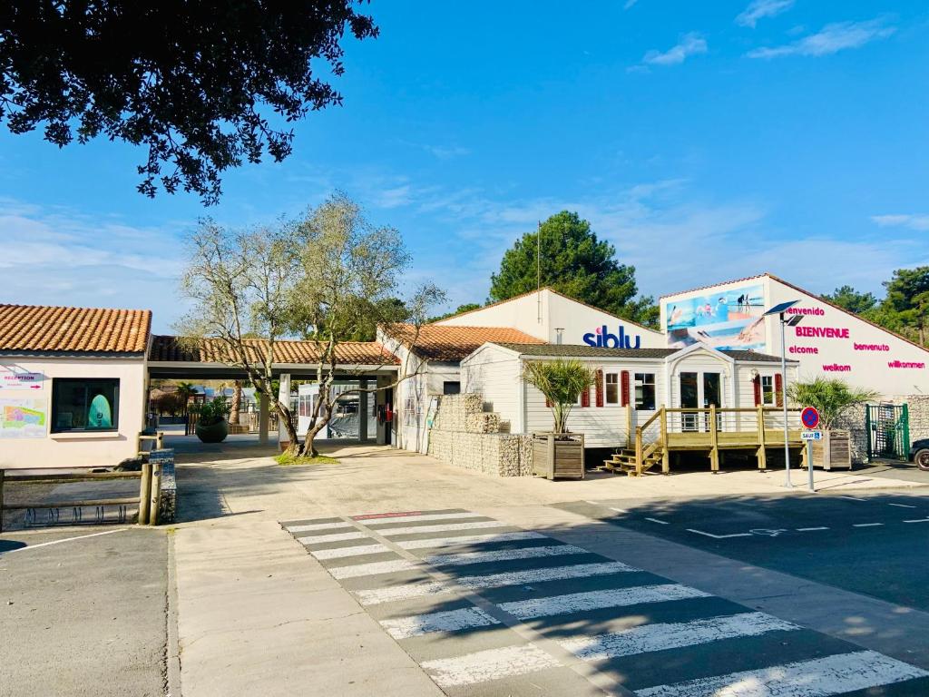 a street with two buildings on the side of a road at MOBIL HOME LUXUEUX 40m2 - 3ch - Camping 4 étoiles 79 - LA PIGNADE in La Tremblade