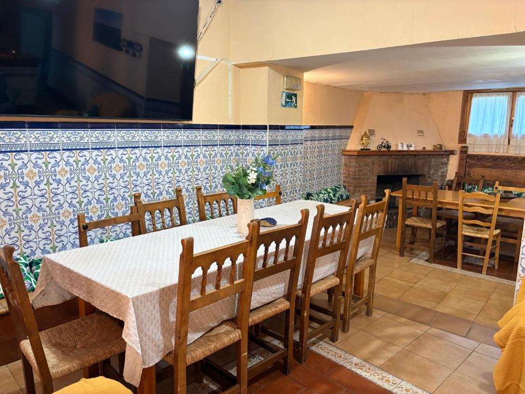 a dining room with a table and chairs and a fireplace at Hostal San José in Naval