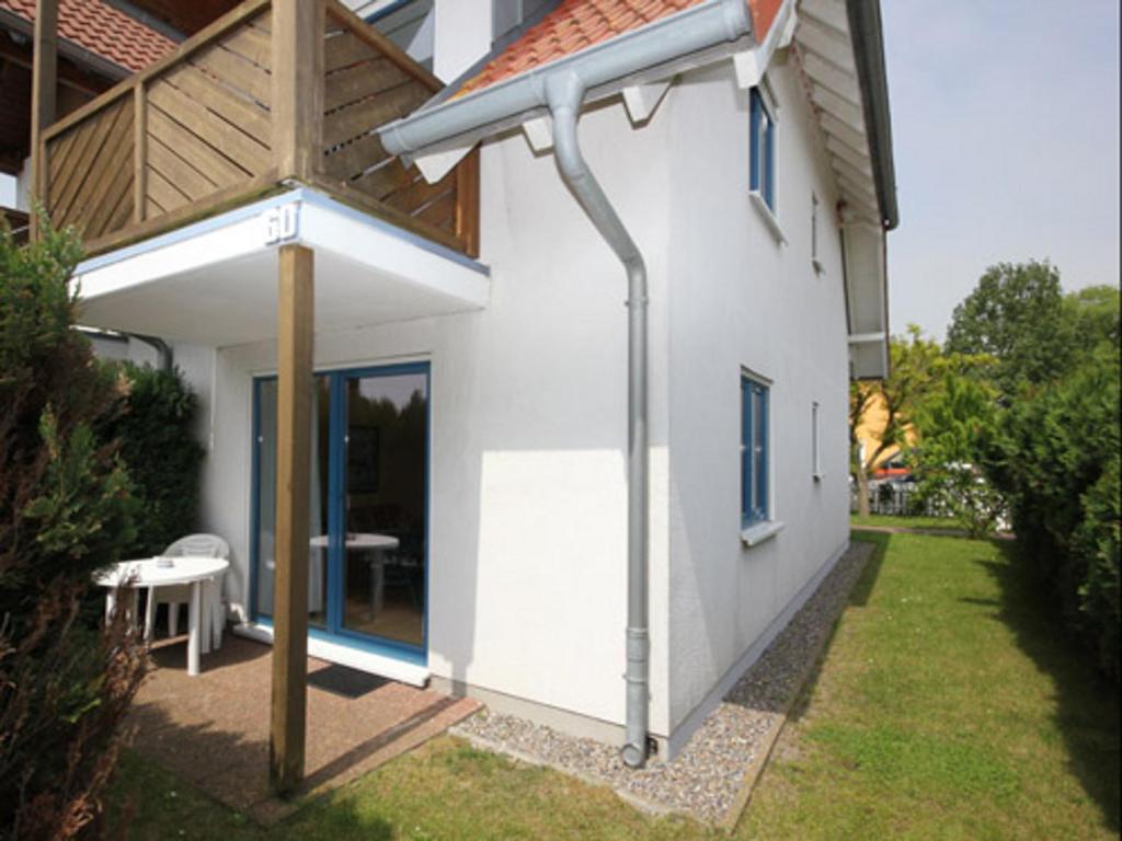 une maison blanche avec un solarium sur son côté dans l'établissement Prise1 Ferienwohnung Breege, à Breege