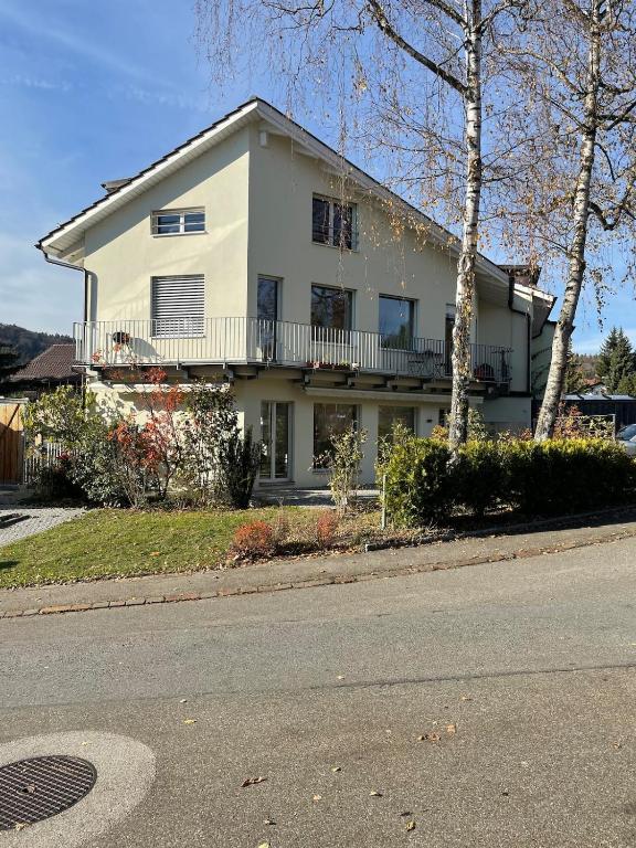 a white house on the side of a street at Your exclusive 2 room & 2 bathroom natural holiday home in Winterthur