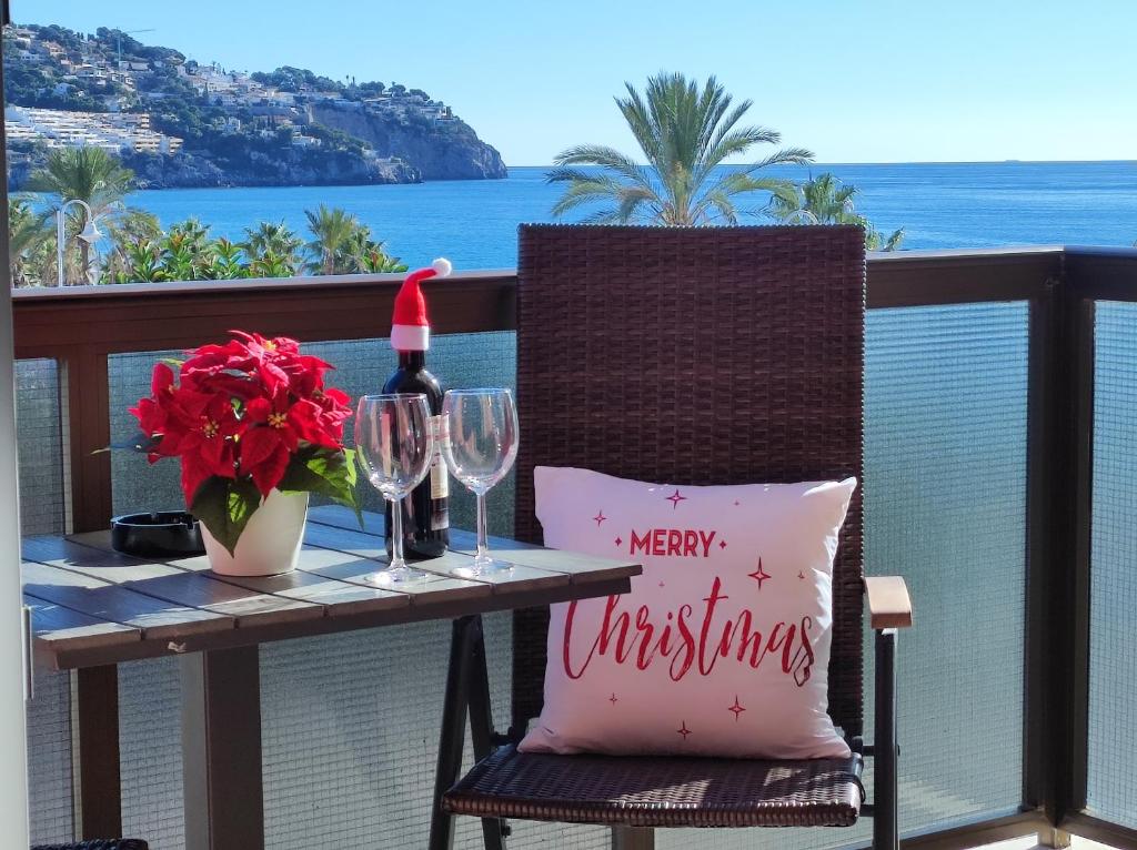 a merry christmas pillow on a table on a balcony at Bahia Deluxe in La Herradura