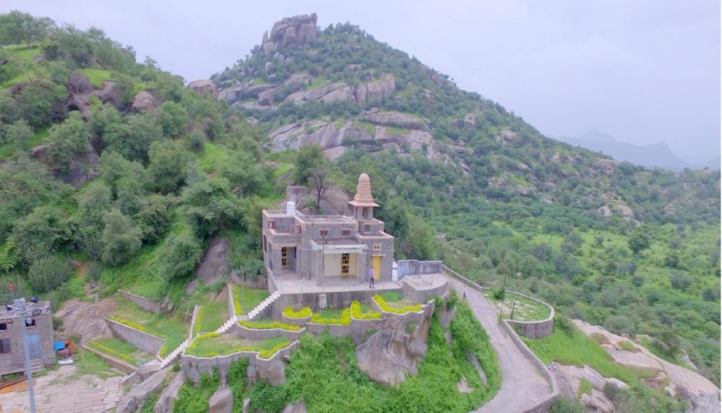 a building on top of a hill with a mountain at Jawai Dam Stay and Leopard Safari 